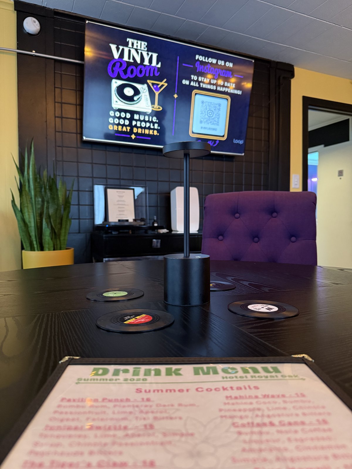 The Vinyl Room — vinyl-record coasters and summer cocktail menu on a round table